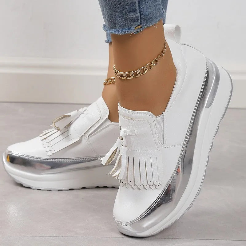 Women's black casual shoes with tassel detail and muffin wedge heel on white background