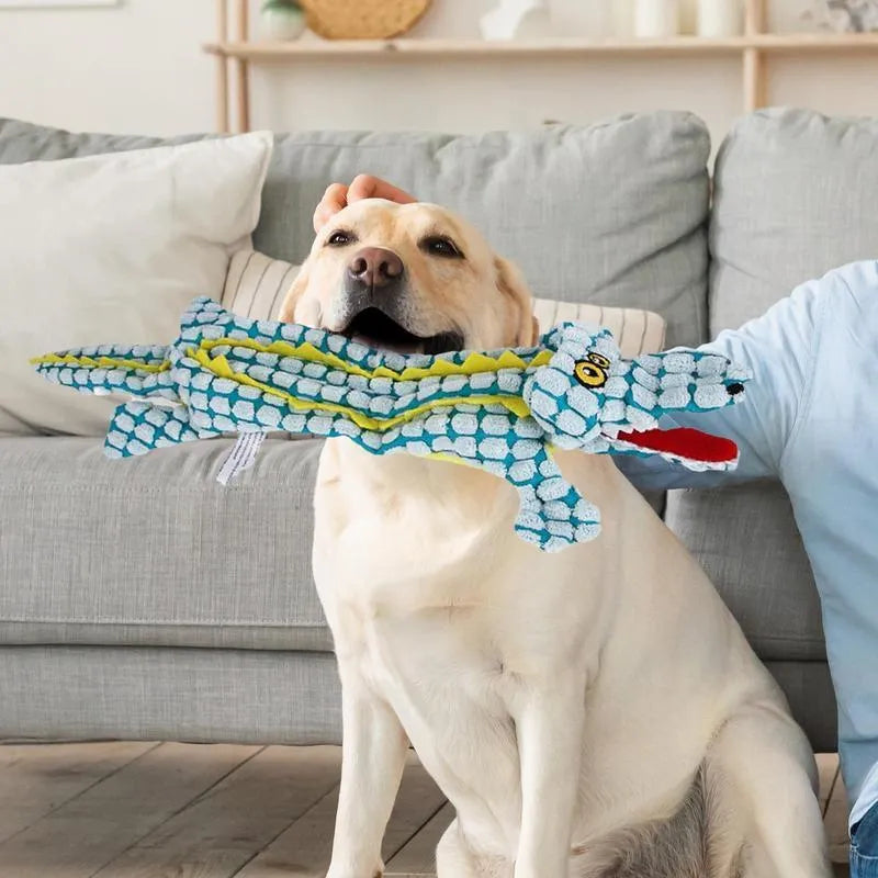 Blue plush crocodile-shaped dog toy with corduroy texture and squeaker, shown next to measuring tape