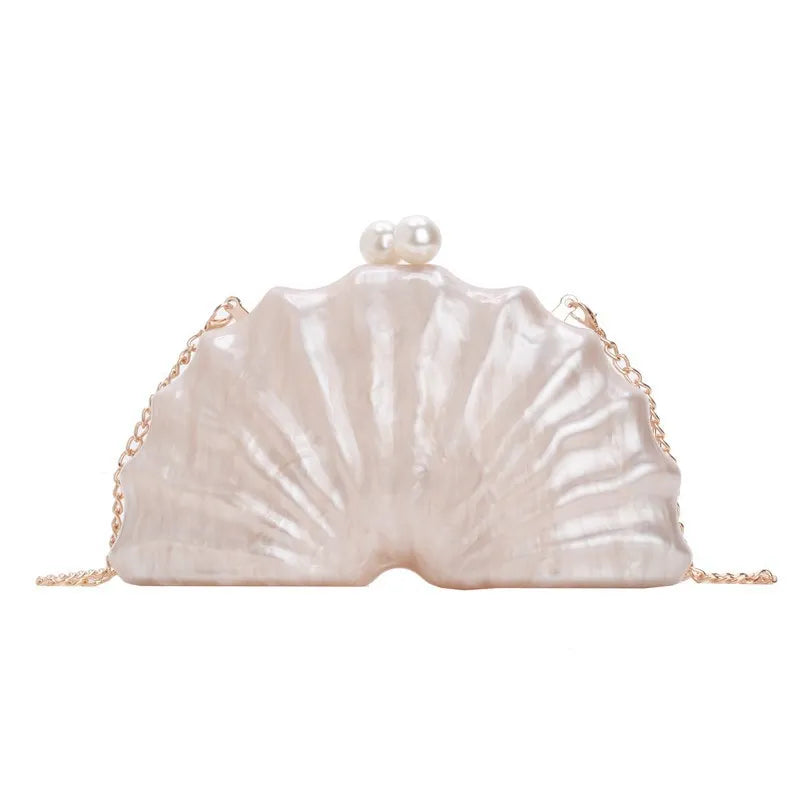 Acrylic shell-shaped clutch bag in champagne colour with chain detail on solid background