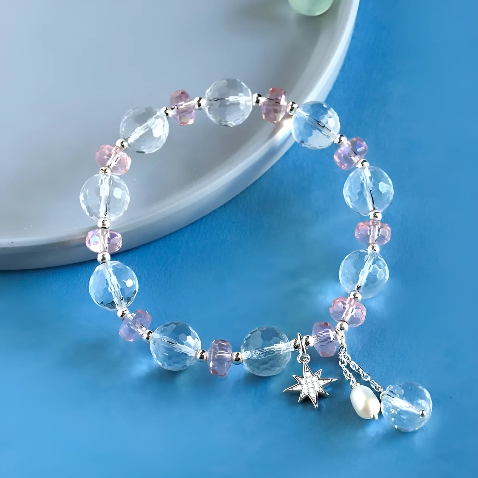Women's white crystal bracelet with diamond shapes and lucky cat charm on wrist