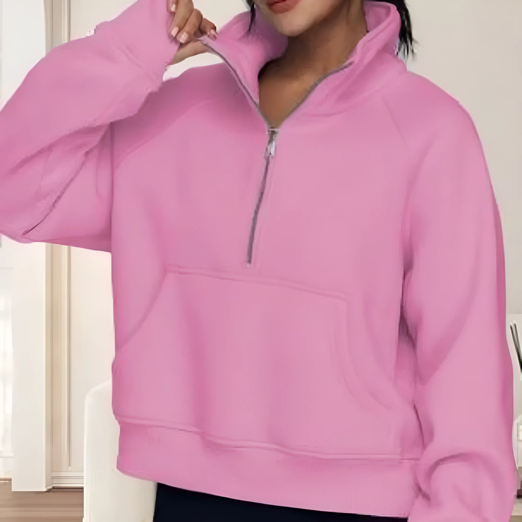 A woman wearing a loose-fitting apricot-coloured fleece-lined sweater with a lapel neckline and raglan sleeves.