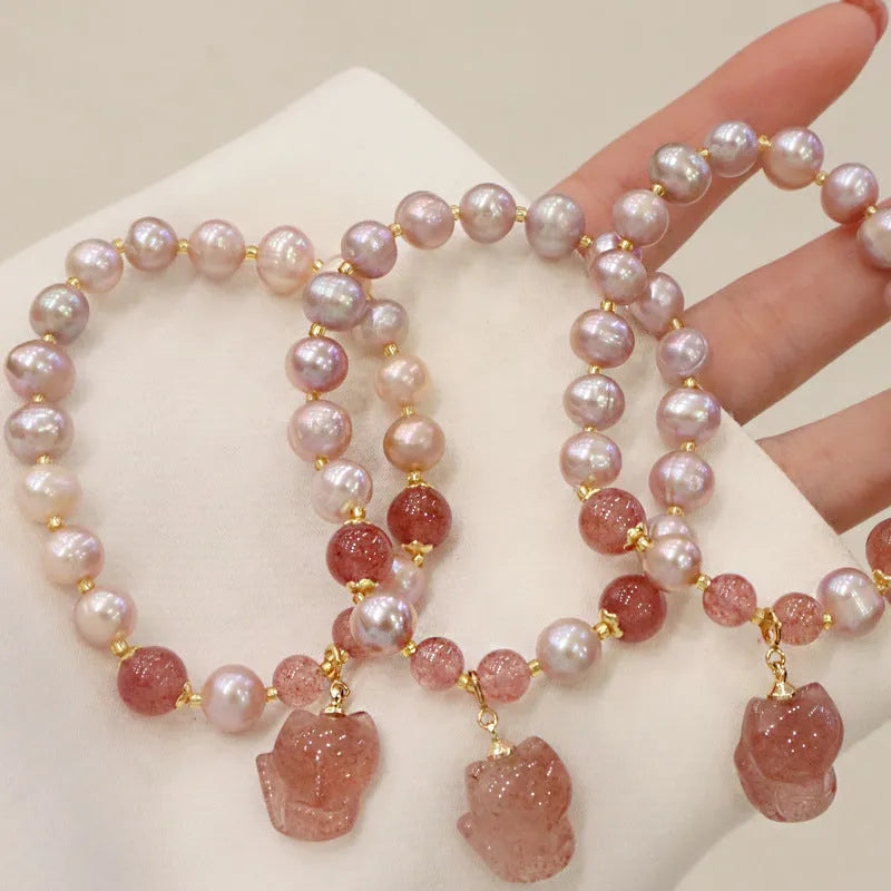 Light pink freshwater pearl bracelet with silver fox charm and strawberry quartz detail on adjustable strand