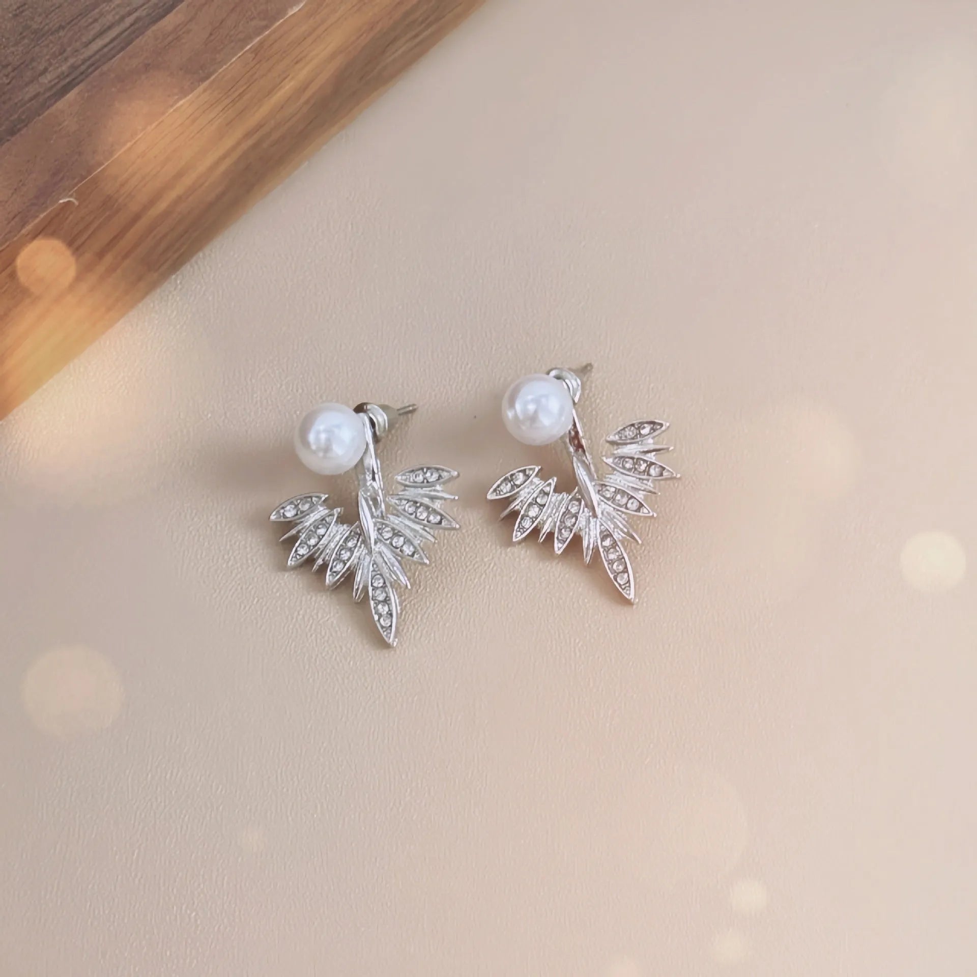 Silver ladies backward-hanging wing pearl earrings with diamond setting on alloy base