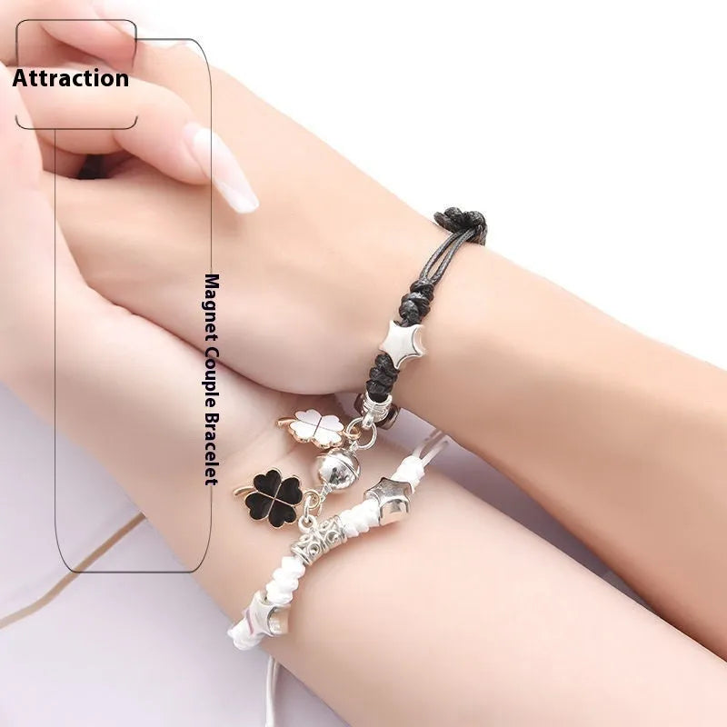 A pair of magnetic couple bracelets with alloy charms showing an I love you design and a key lock on a textured background.