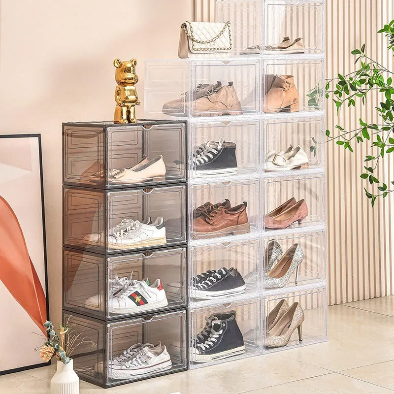 Clear acrylic shoe storage box with magnetic side door open, showing shoes inside.