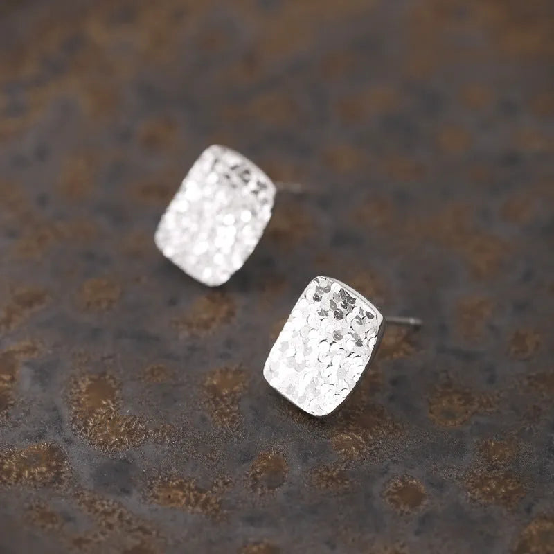 Pair of crushed ice square 925 silver stud earrings with white gold colour finish and geometric carved surface