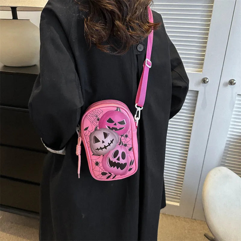 Black Halloween crossbody bag with cartoon pumpkin, ghost, and bat print, showing front and strap.