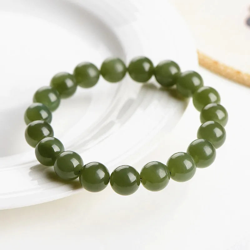 Unisex Hetian Jade ball bracelet with polished beads in clear colours on a wrist.
