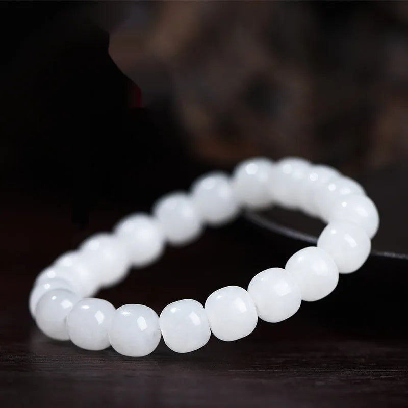 Handmade white Hetian jade barrel bead bracelet for men and women on a wrist.