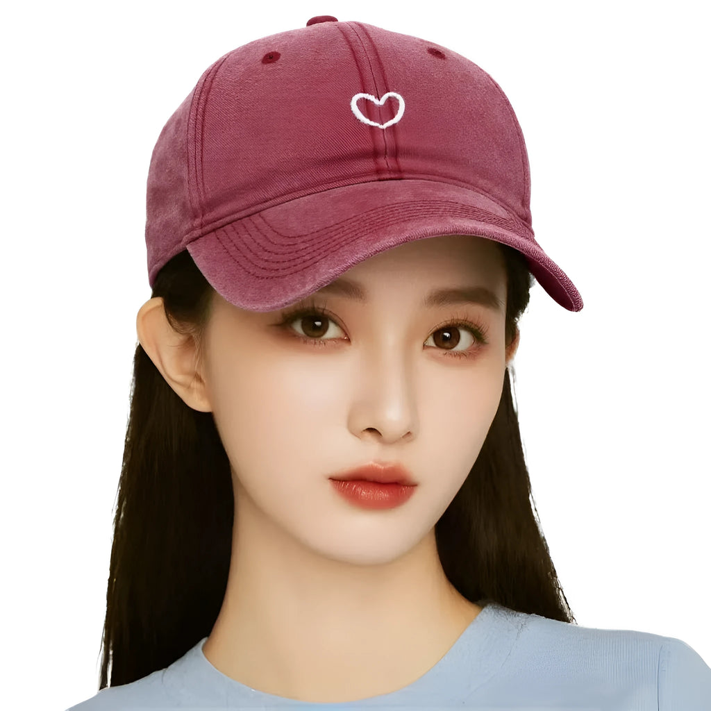 Adjustable cotton baseball cap featuring a distressed embroidered love heart on the front, shown in a selection of colours.
