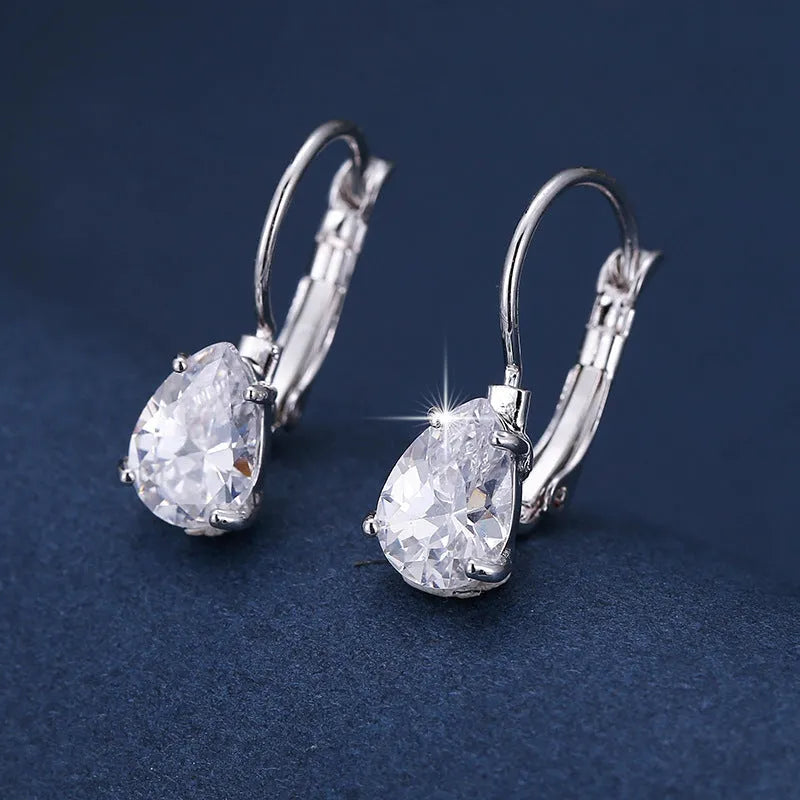 Gold and platinum drop earrings with a cubic zirconia stone set in a simple metal design.
