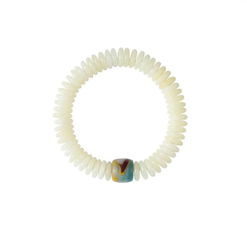 A white Bodhi seed bracelet shown in both a looped wrist style and a straight handheld style.