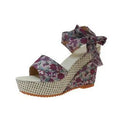Women's floral patterned peep toe wedge sandals with an ankle strap buckle.