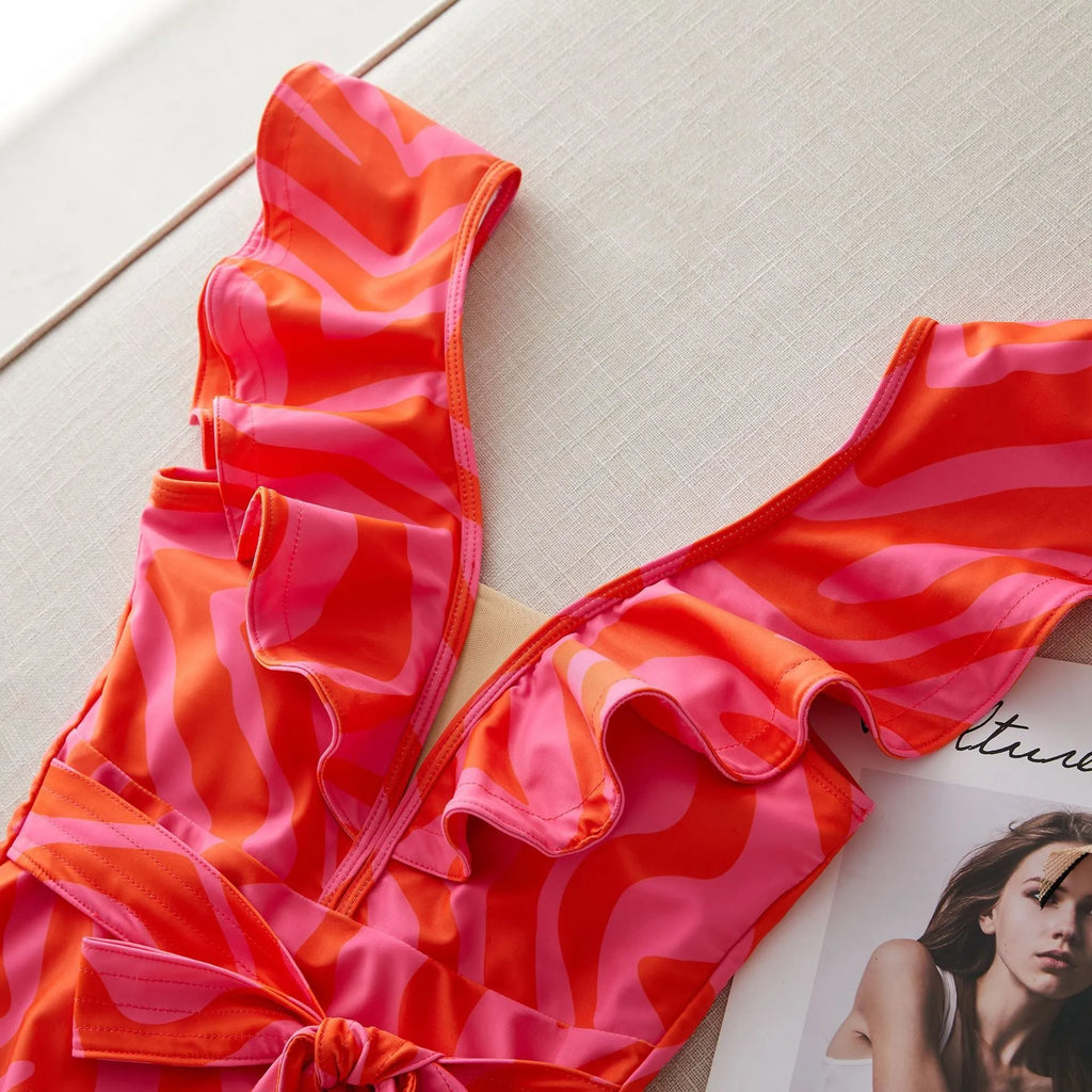 Women's printed one-piece swimsuit with ruffles on both shoulders and mesh stitching on the deep V-neck.