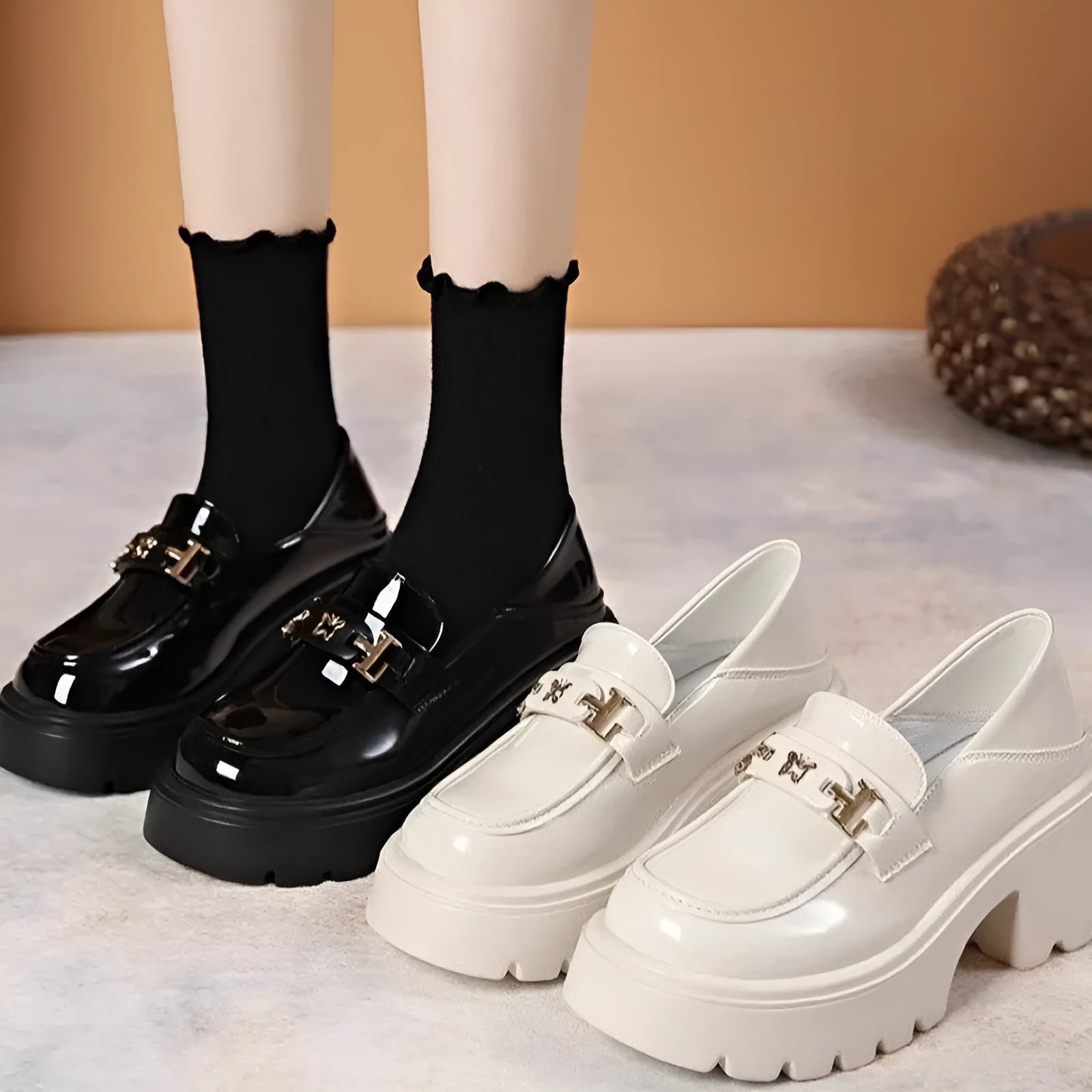 Black slip-on chunky heel shoes with a skull pattern on the front and a square rubber sole.