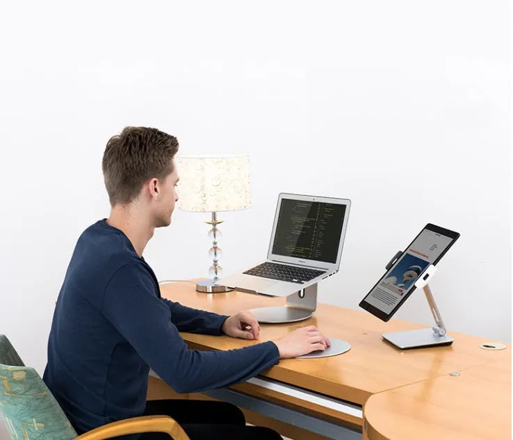 Silver foldable tablet stand showing 360-degree rotation mechanism with silicone anti-slip pads