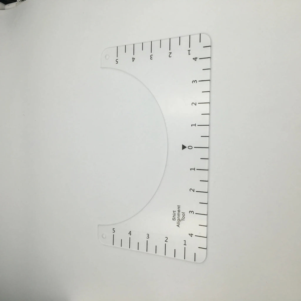 Transparent acrylic sewing ruler template for T-shirt patch alignment showing etched measurement markings