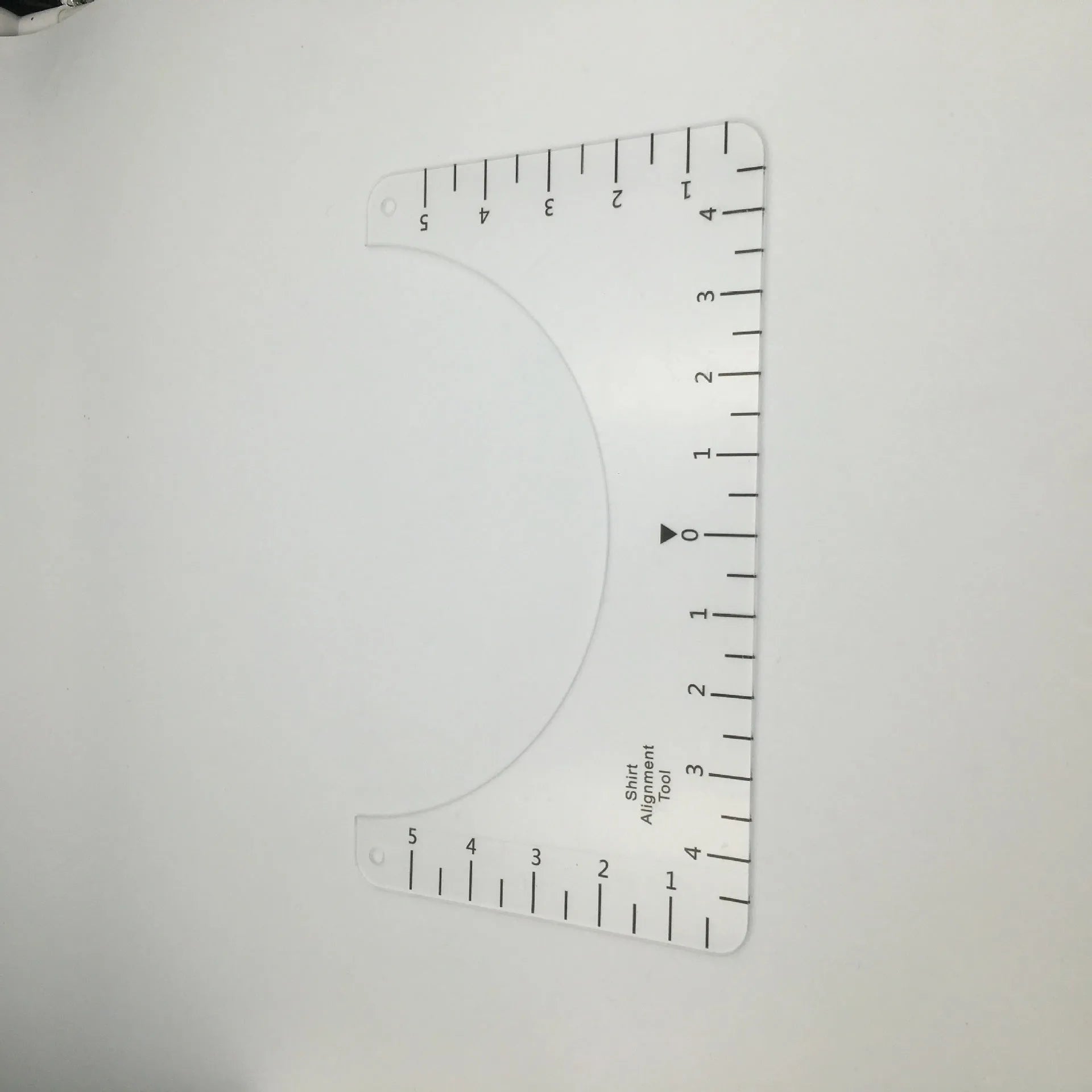 Transparent acrylic sewing ruler template for T-shirt patch alignment showing etched measurement markings