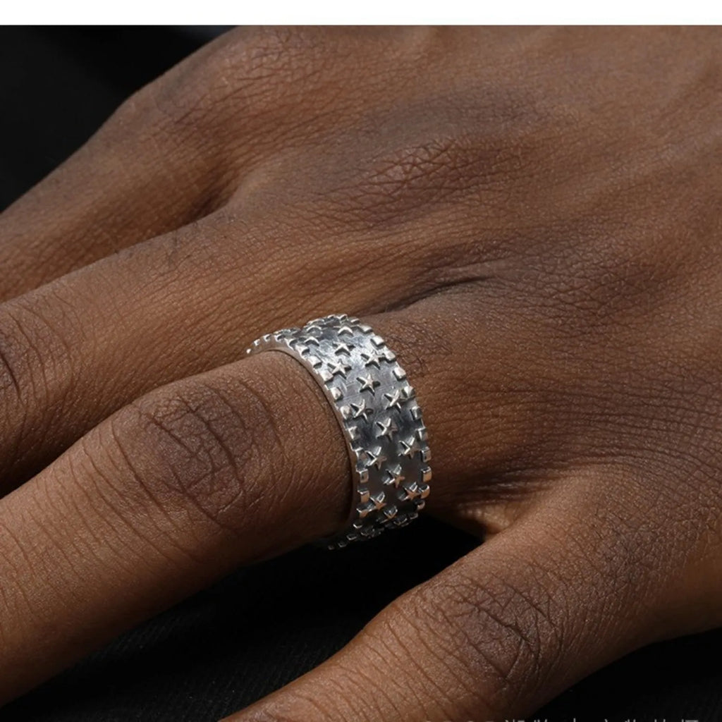 Adjustable silver ring with a geometric pattern of multiple five-pointed stars on the band.
