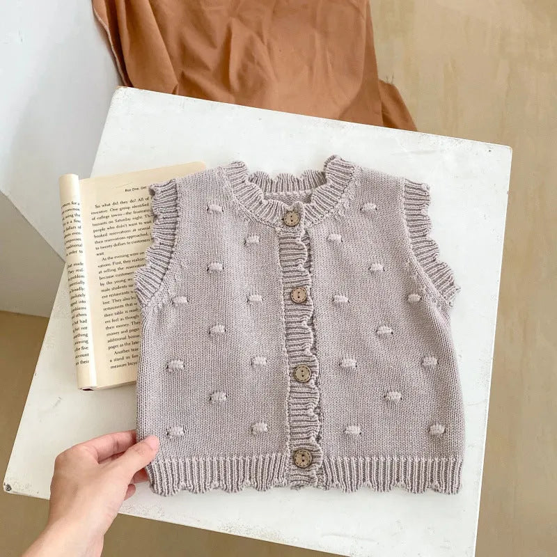 Children's knitted polka dot vest in apricot with single-breasted closure, featuring a sleeveless design for spring and autumn