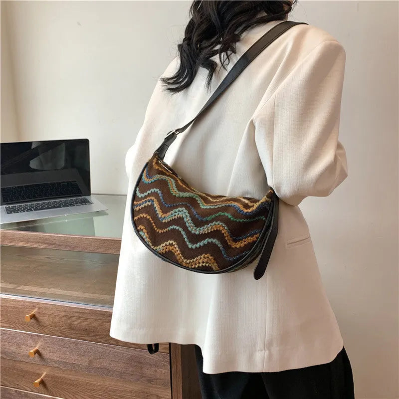 Straw woven crossbody bag showing woven texture and internal phone compartment
