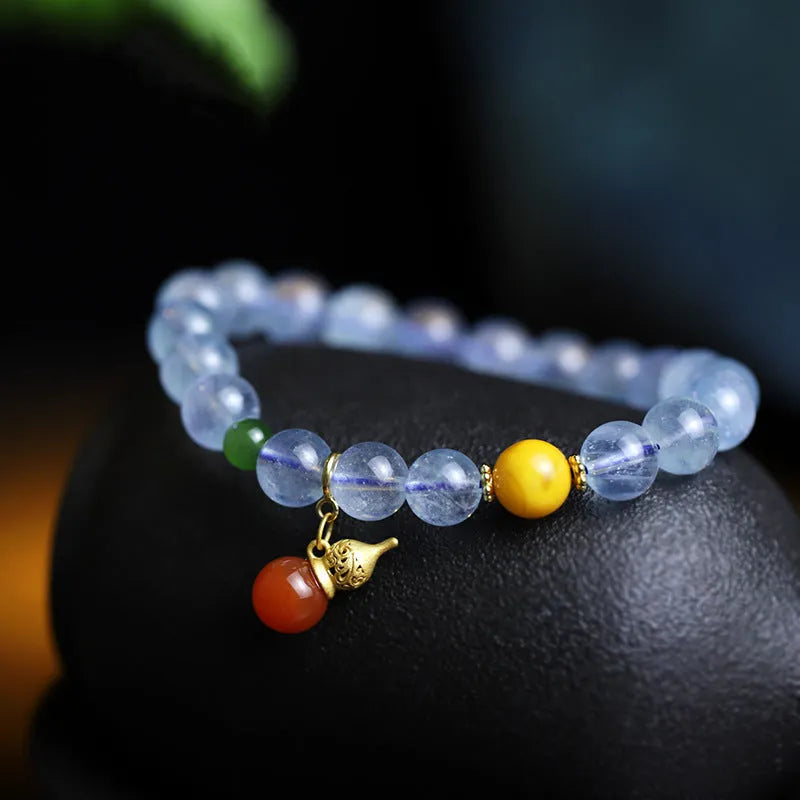 Geometric women's bracelet with 8mm iced aquamarine stones on a wrist.