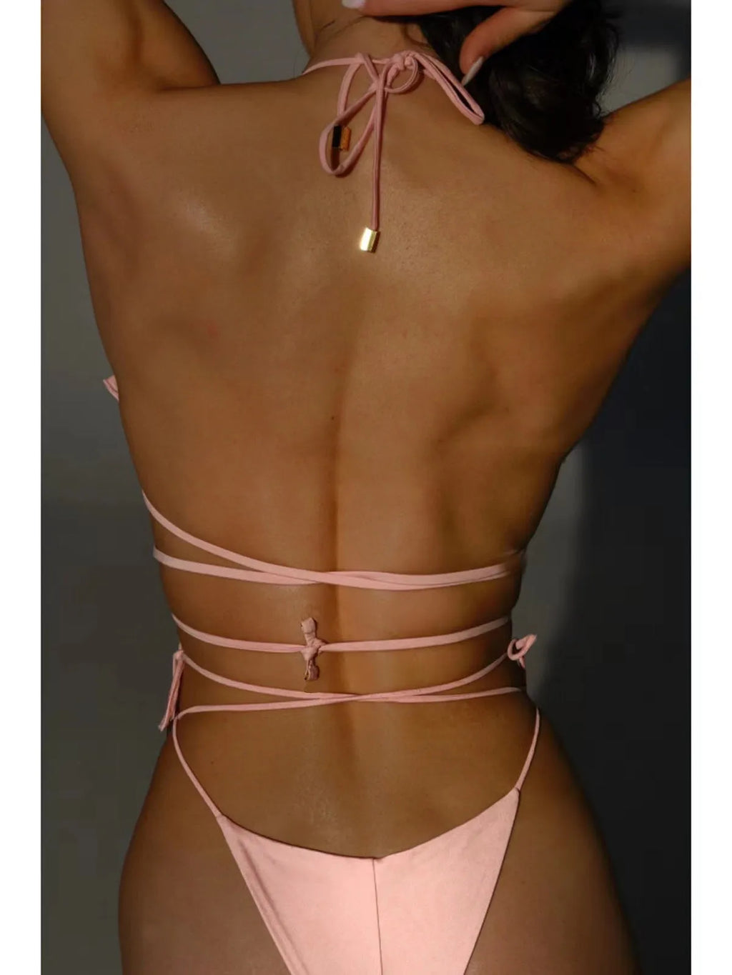 Pink halter lace-up three-dimensional flower bikini set on female model, backless brief style for swimming
