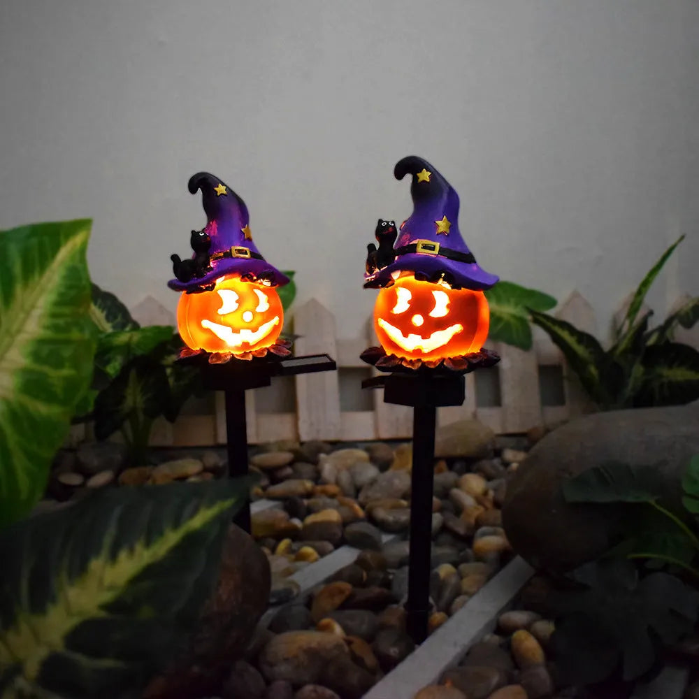 Solar Halloween pumpkin lantern with wizard pumpkin style on a garden path, wrought iron frame