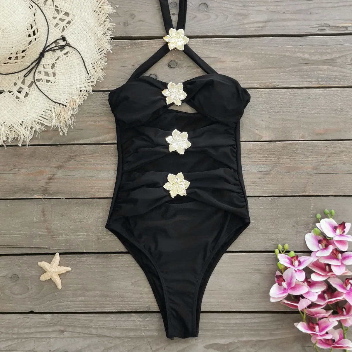 Women's solid colour one-piece swimsuit with hollow-out tube top and matching short skirt in black.