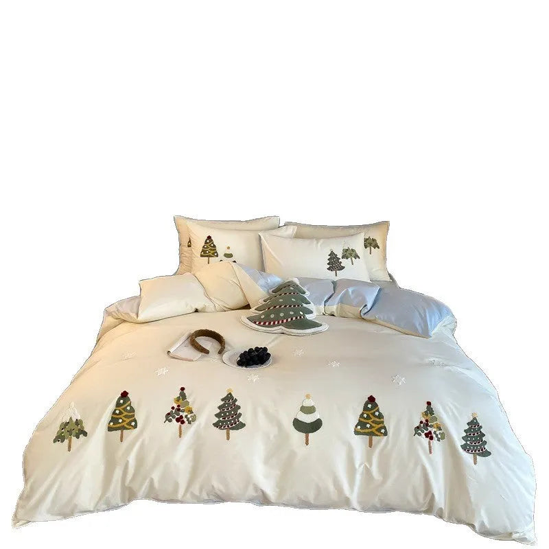 Pure cotton Christmas tree towel embroidery bedding four-piece set in cream blue on a bed.
