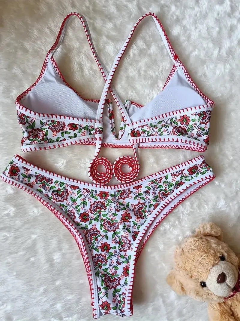 Women's one-piece swimsuit with V-neck embroidery and floral print on blue background.