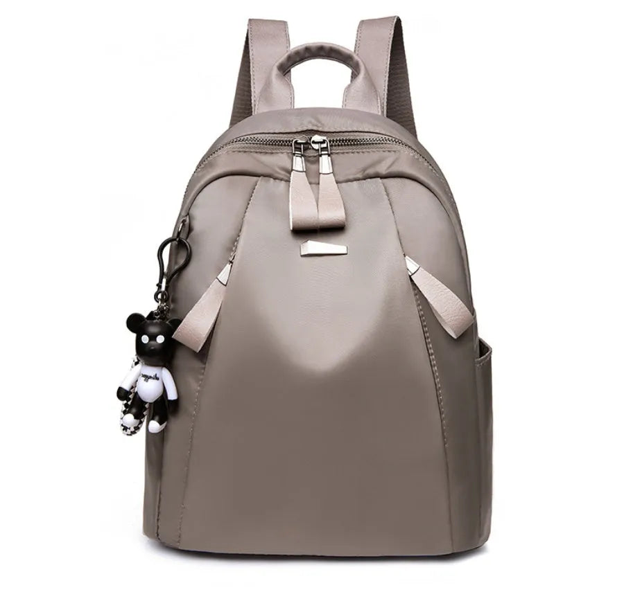 Medium square-shaped Oxford cloth rucksack in grey with double straps and a soft handle.