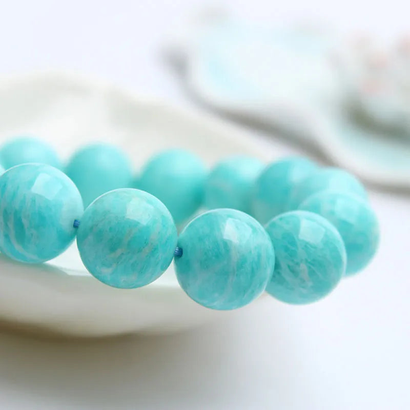 Blue-green amazonite stone beaded bracelet with adjustable string closure.