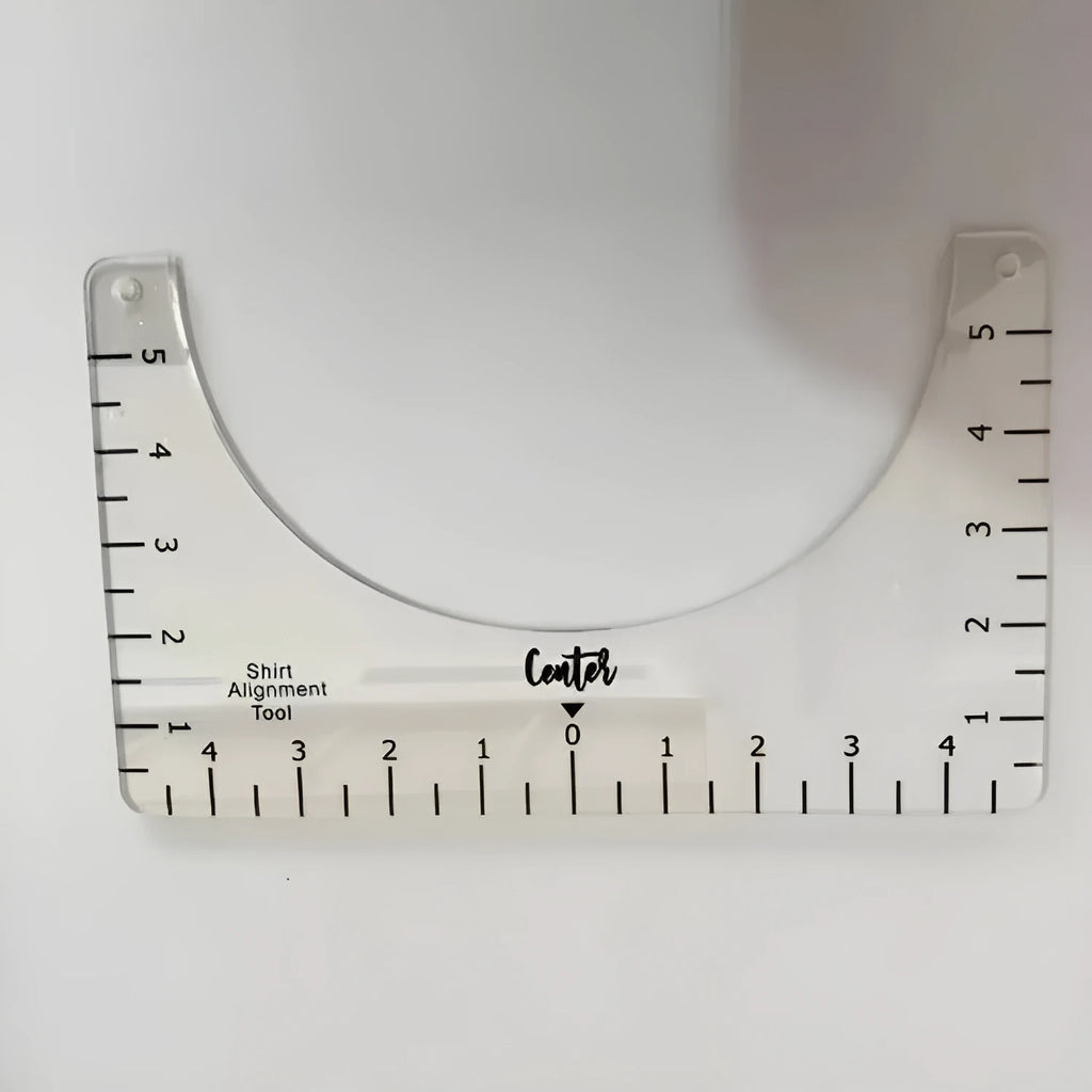 Transparent acrylic sewing ruler template for T-shirt patch alignment showing etched measurement markings