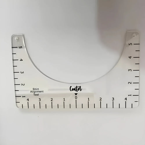 Transparent acrylic sewing ruler template for T-shirt patch alignment showing etched measurement markings