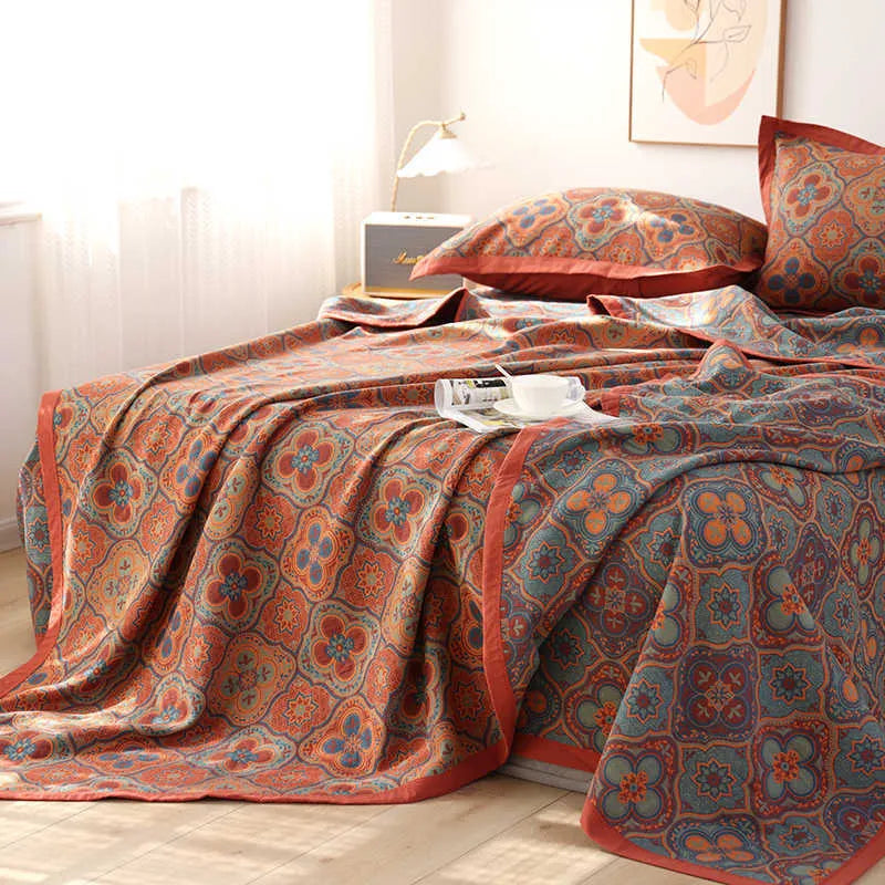 Cotton gauze bed blanket set with floral pattern and two matching pillowcases laid on a bed