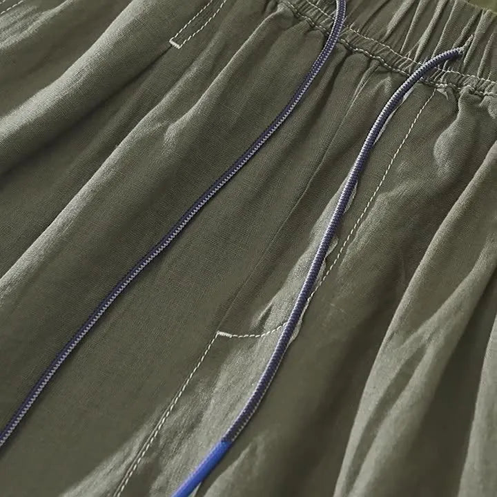 Men's straight-leg linen shorts in black or green with drooping style and drawstring mid-waist.