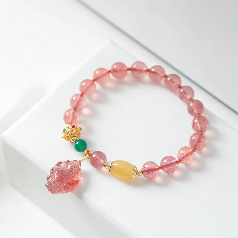 Women's crystal beaded bracelet with a strawberry quartz nine tail fox charm on a white background.