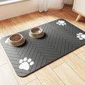 Blue diatomite pet feeding mat under a dog's water and food bowl on a wooden floor.