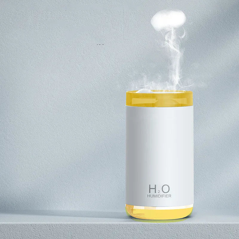 White portable USB humidifier emitting jellyfish-shaped smoke rings with a warm glowing night light on a desk