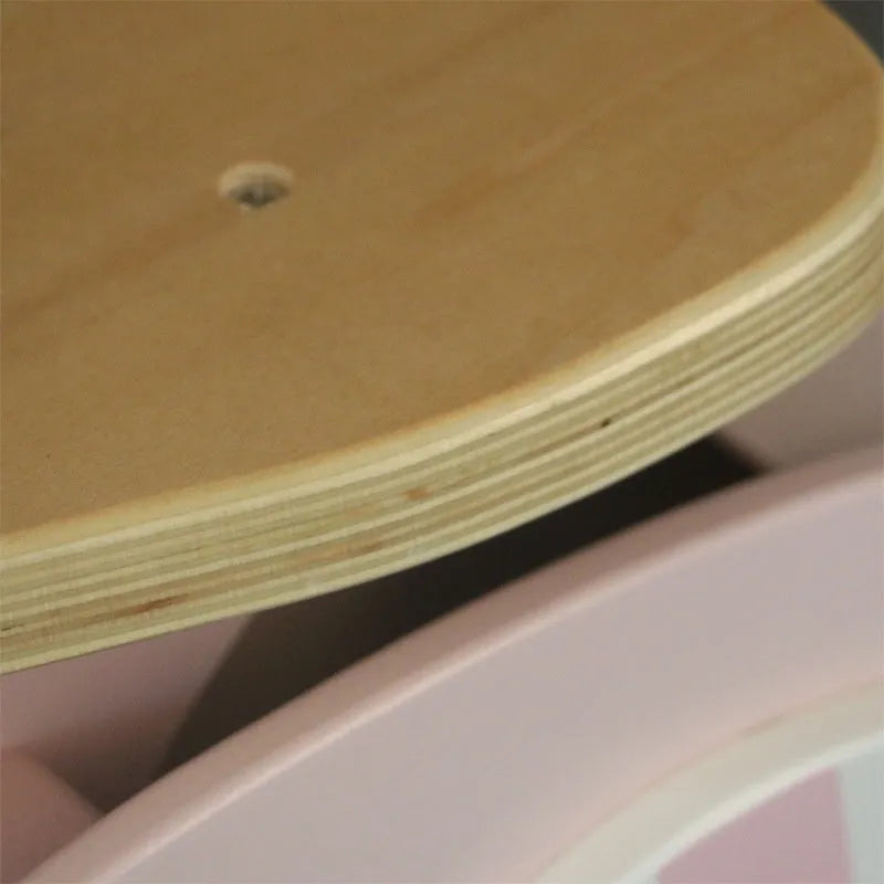 A pink wooden balance scooter for toddlers and children with a 10-inch deck.
