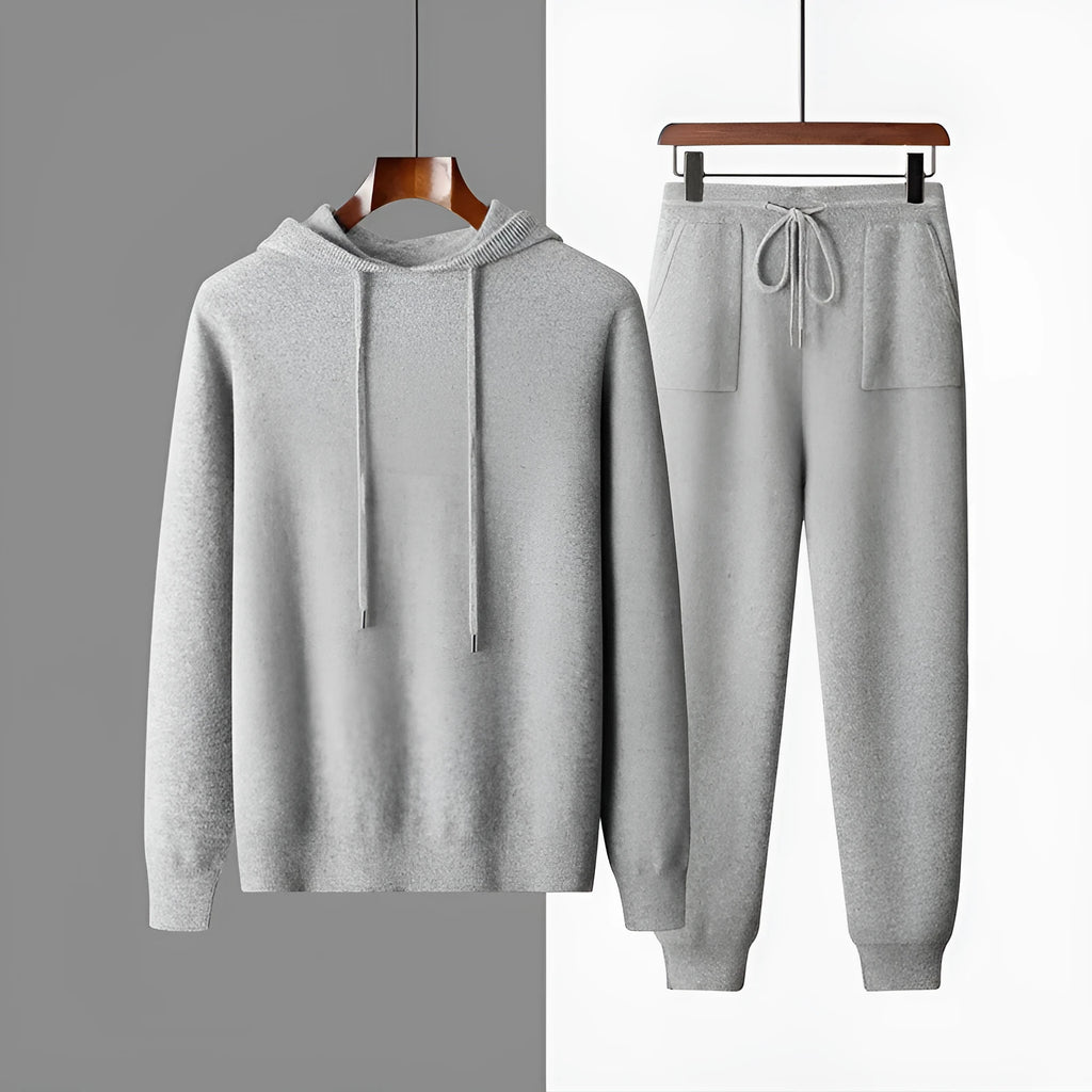 Man wearing a light grey cashmere hooded sweatshirt and matching trousers, a casual winter two-piece set.