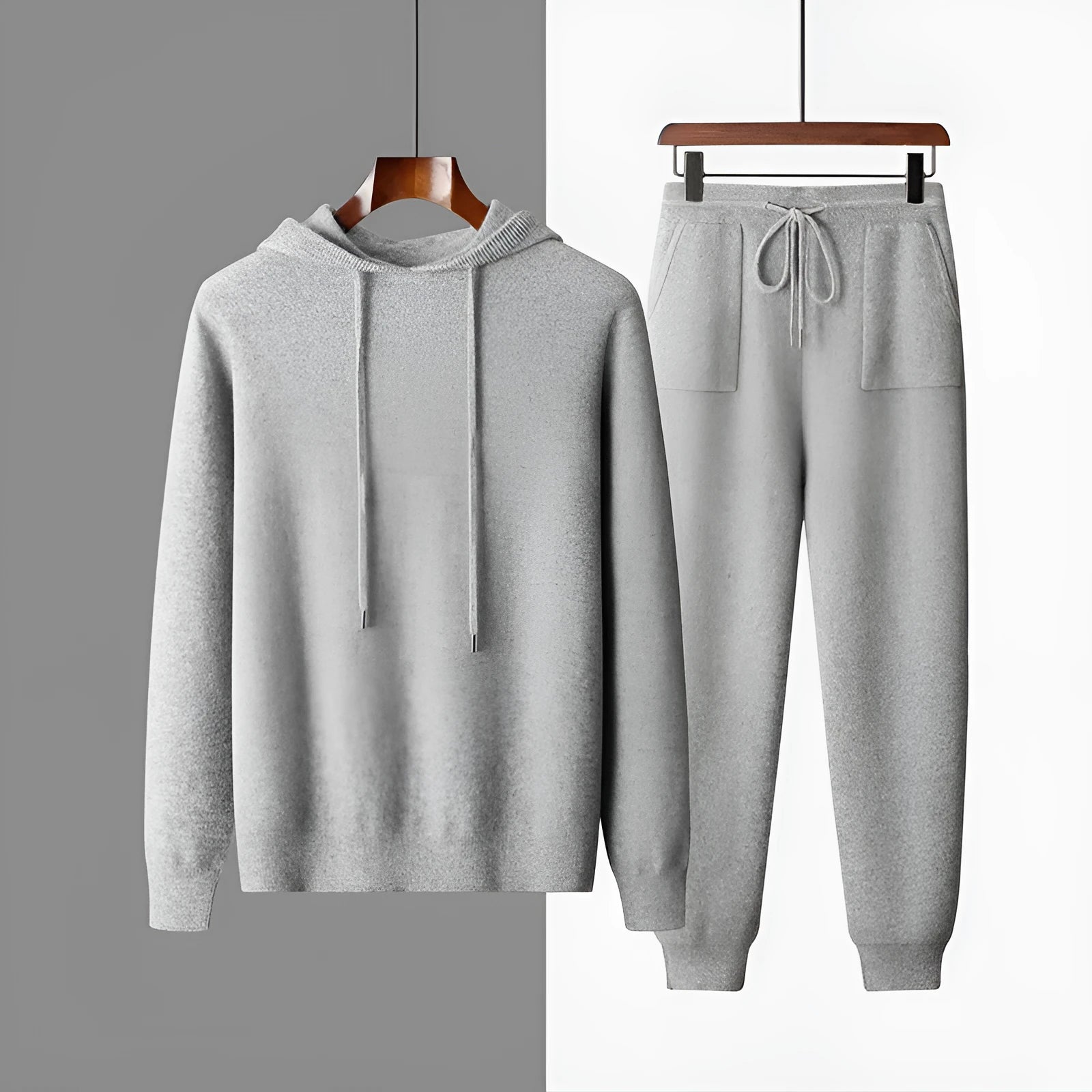 Man wearing a light grey cashmere hooded sweatshirt and matching trousers, a casual winter two-piece set.