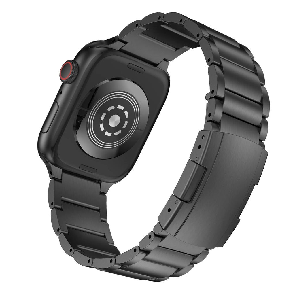 Black titanium metal Apple Watch band with a folding buckle on a table