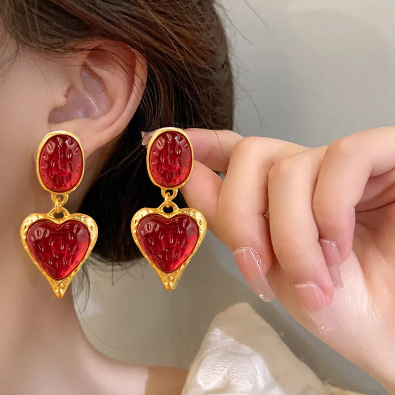 Oval heart-shaped alloy stud earrings with silver pleated edge, shown in purple, red, green, and yellow/white colour options.