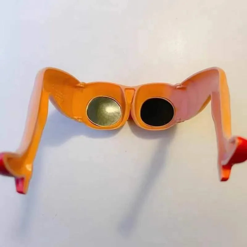 Orange novelty sunglasses with a unique leg hip personality silhouette on a solid background.