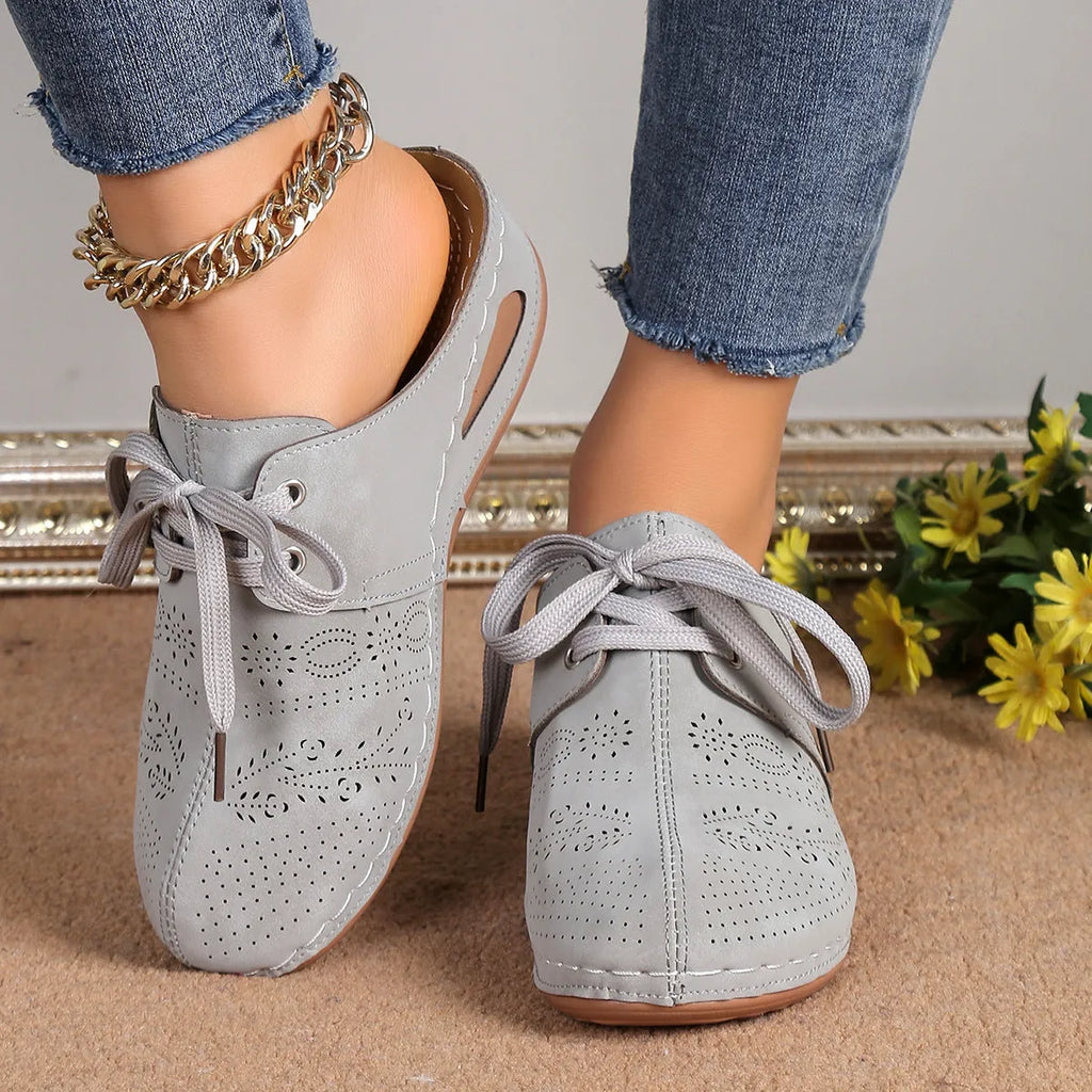 Women's black lace-up wedge slippers with hollow-out design, suede upper, and rubber sole.