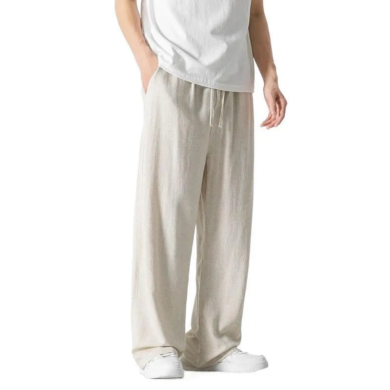 Man wearing beige cropped straight-leg linen trousers with a drawstring waist.