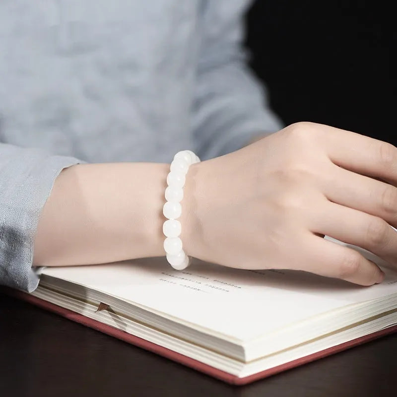 Handmade white Hetian jade barrel bead bracelet for men and women on a wrist.
