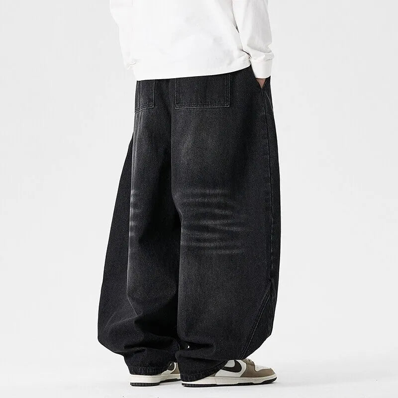 Men's plus size baggy blue denim jeans with a straight leg and low waist on a hanger.